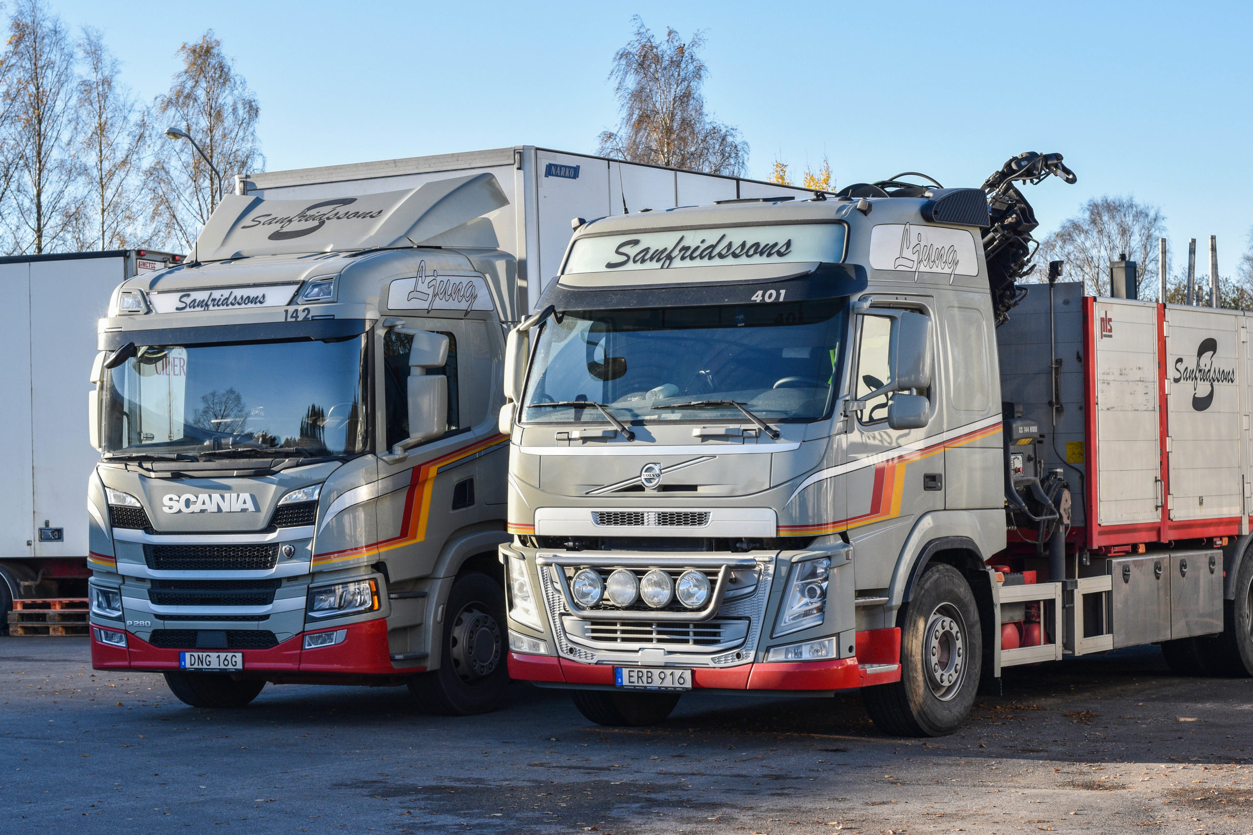 Två stycken distributionsbilar parkerade bredvid varandra.